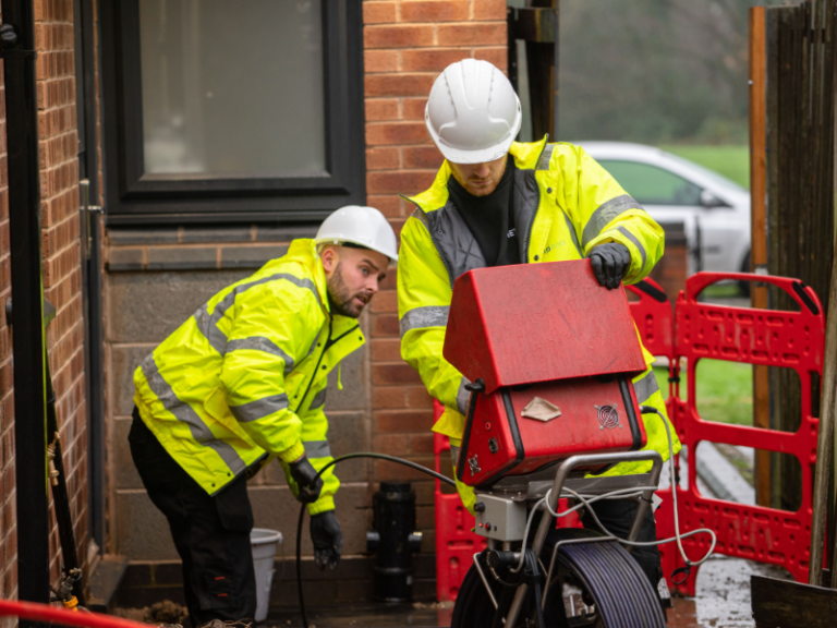 Metro Rod drainage engineers carrying out a CCTV survey in frond of a house